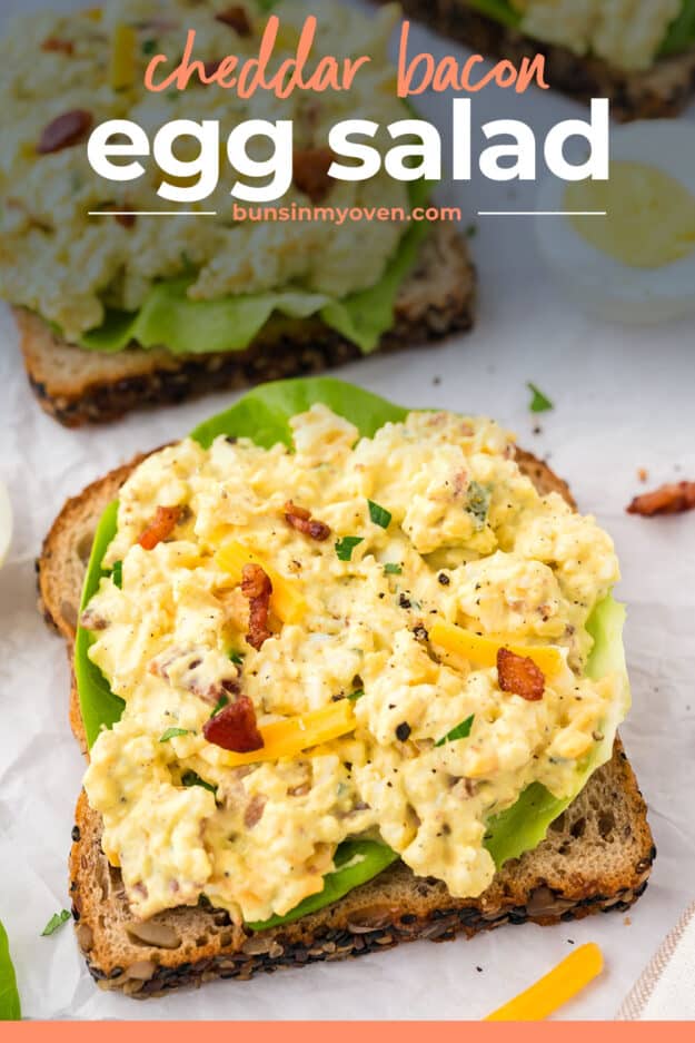 Open faced egg salad sandwich on white counter.