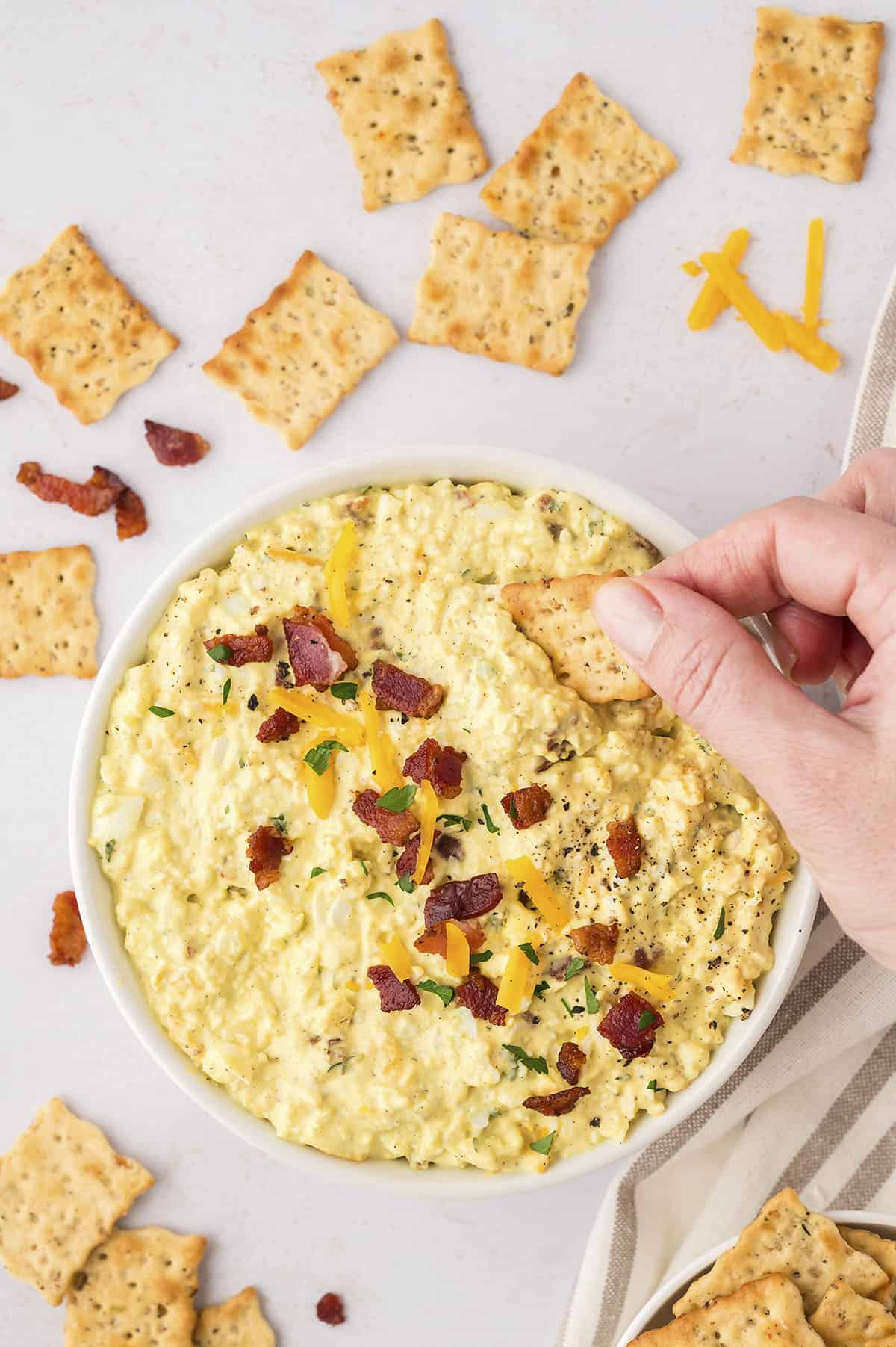 Egg salad with cheddar and bacon on sandwich bread.