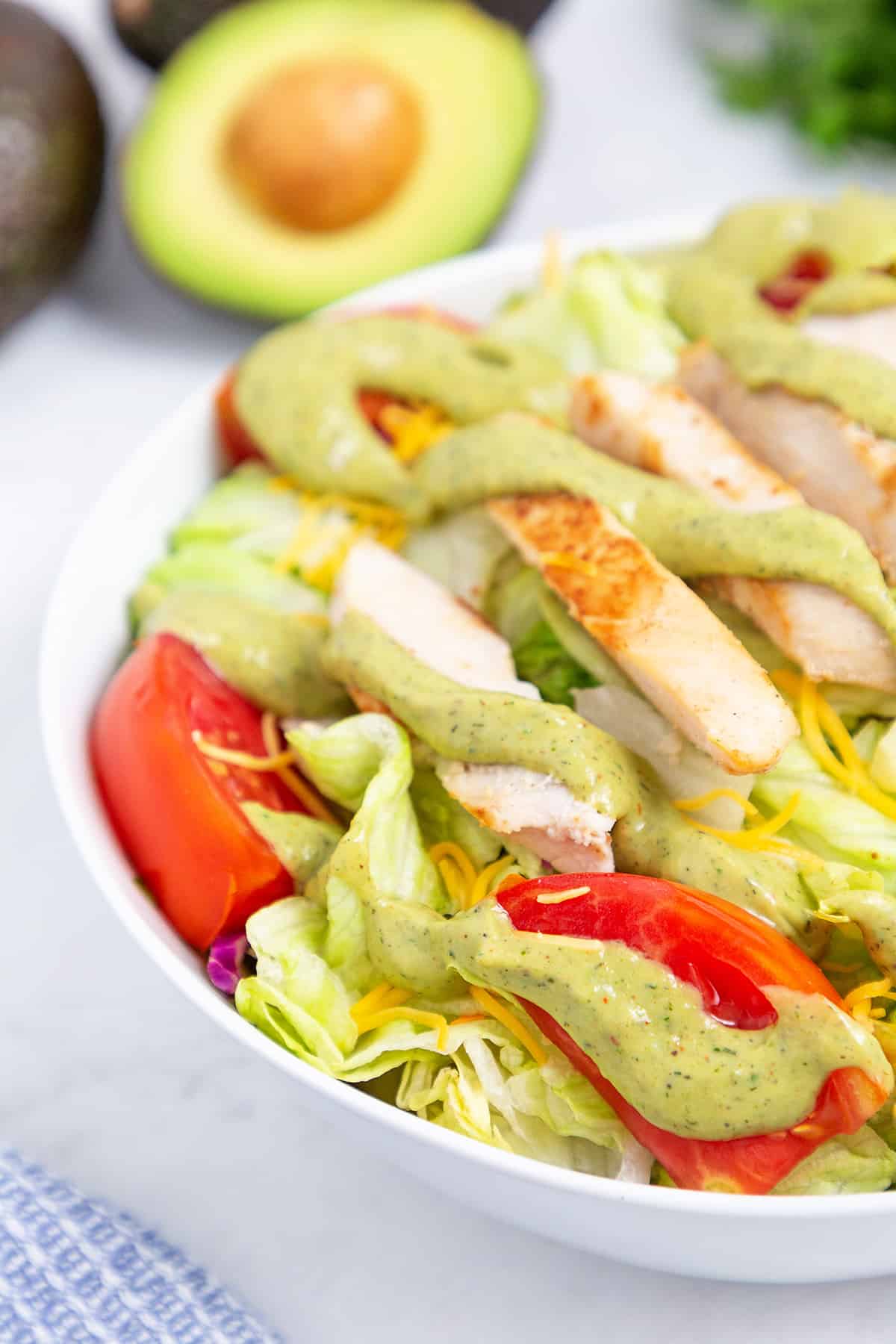 Salad topped with avocado ranch dressing.