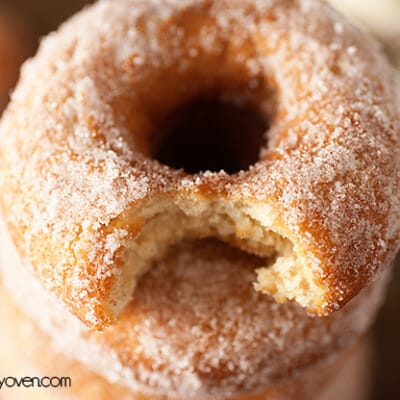 A close up of a doughnut with a bite taken out of it.