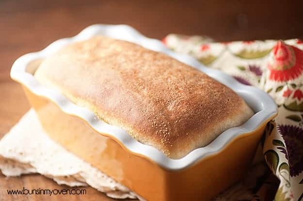 A loaf of english muffin bread in a bread pan.