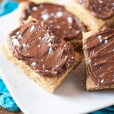 Chocolate fudge peanut butter bars on a square white plate.