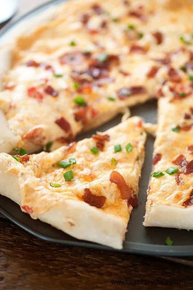 A close up of a triangle slice of pizza on a pizza pan.