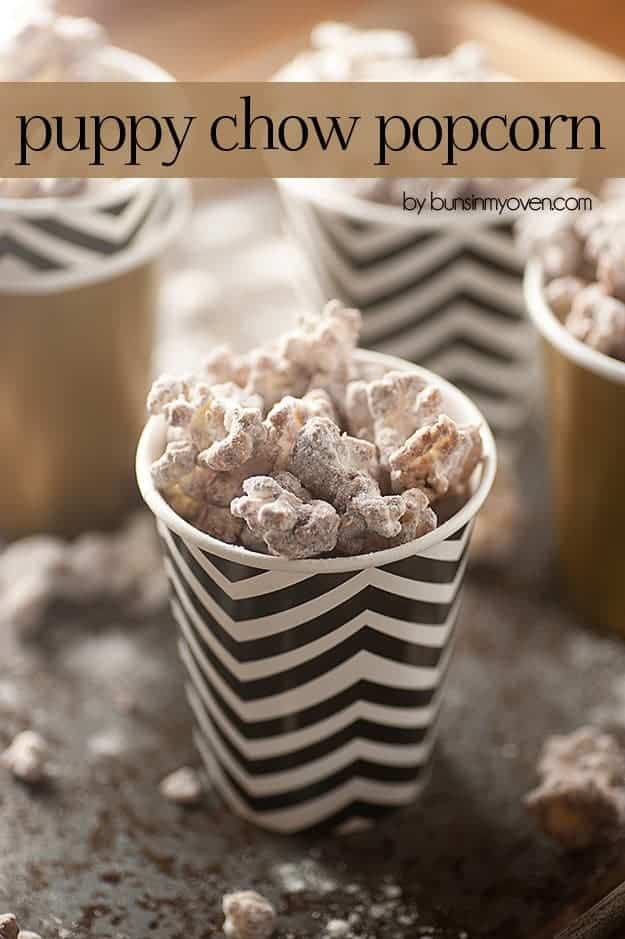 Puppy chow popcorn in a black and white striped paper cup.