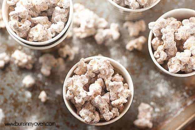 An overhead view of a few paper cups of puppy chow popcorn.