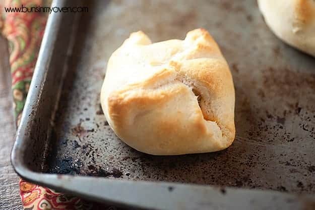 A close up of a cooked biscuit wrapped around a bacon filling.