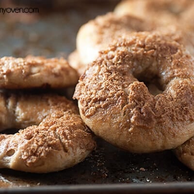 A close up of a stack of bagels topped with cinnamon