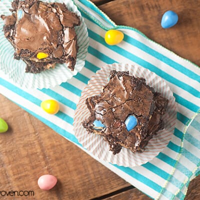 Overhead view of a couple brownies on a striped cloth napkin.