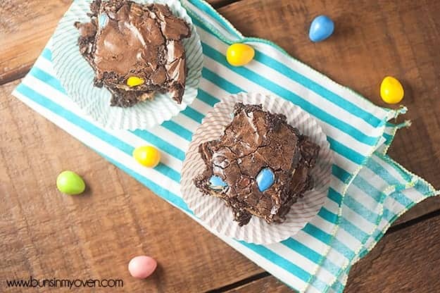 Overhead view of a couple brownies on a striped cloth napkin.