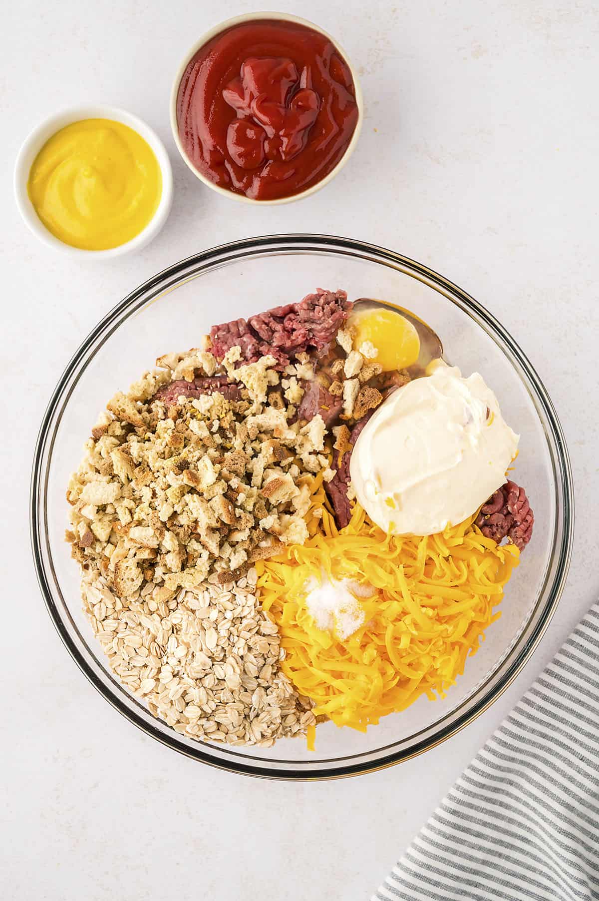 Ingredients for bacon cheeseburger meatloaf in mixing bowl.