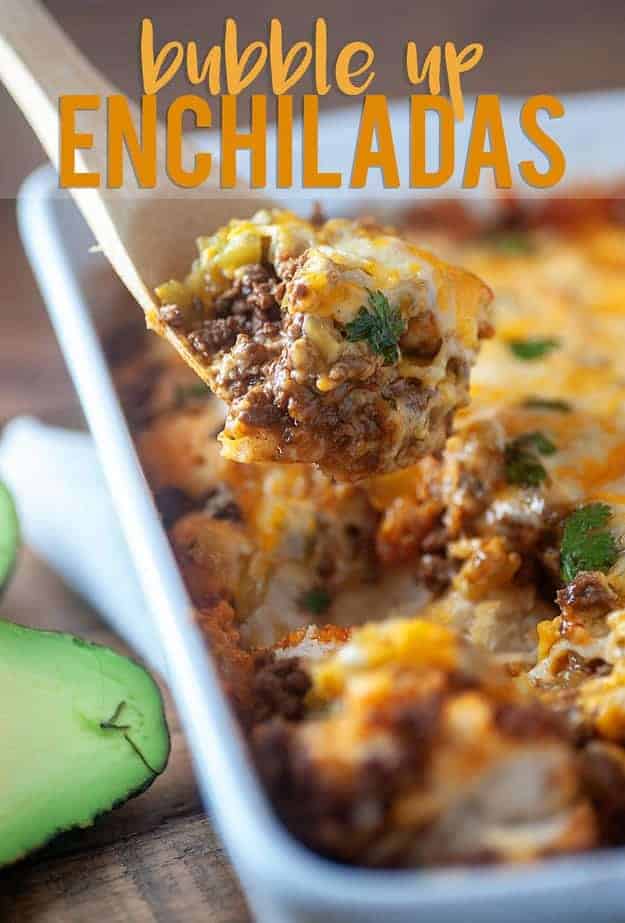 A close up of bubble up enchilada bake on a wooden spoon.