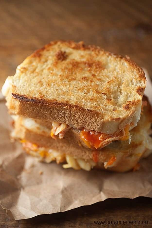 Overhead view of two stacked grilled cheese sandwiches on a table.