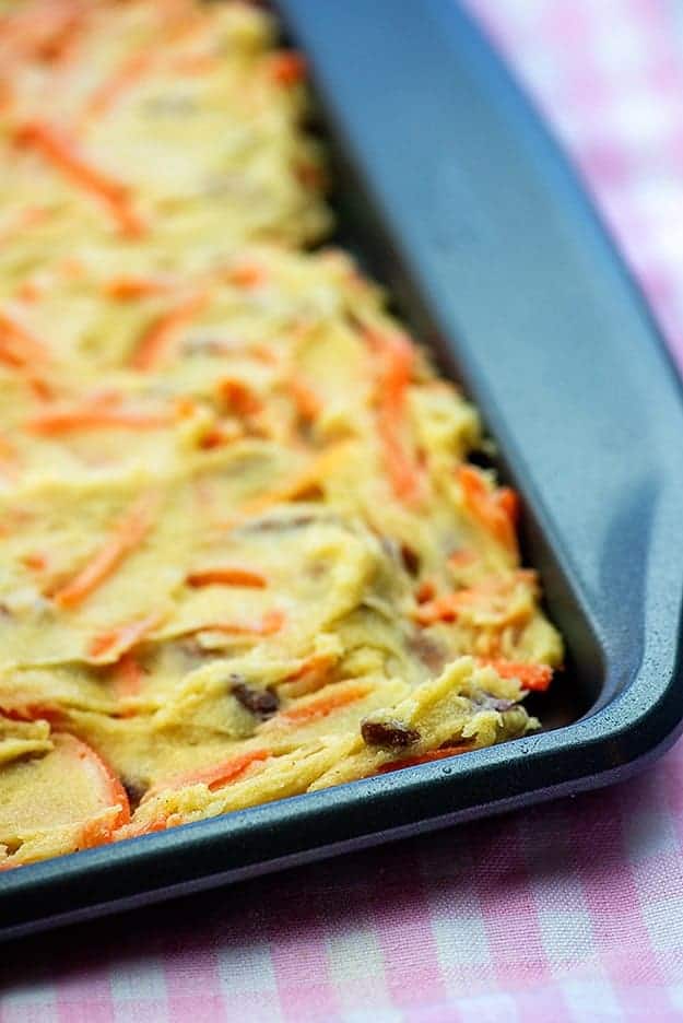 Carrot cake dough spread out on a baking sheet.