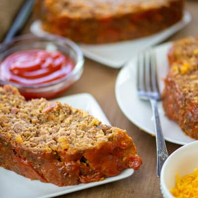 bacon cheeseburger meatloaf on white plates.