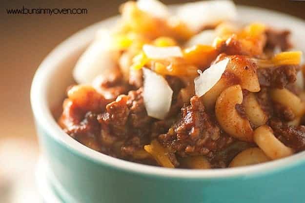 A close up of chili mac with diced onions on top.