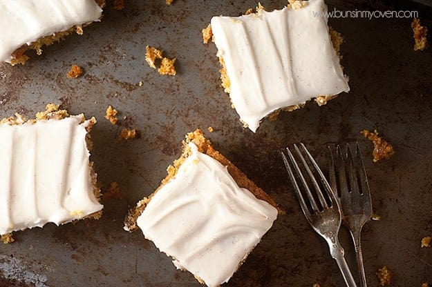 Several squares of carrot cake on a baking sheet with a couple forks.