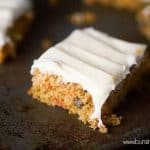 A square slice of carrot cake on a baking sheet.