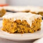 A square slice of carrot cake on a baking sheet.