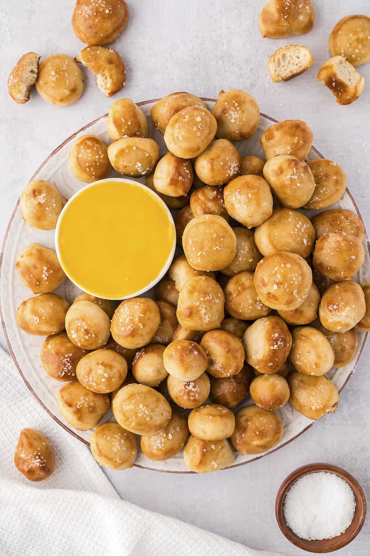 Pretzel bites on platter with cheese sauce,