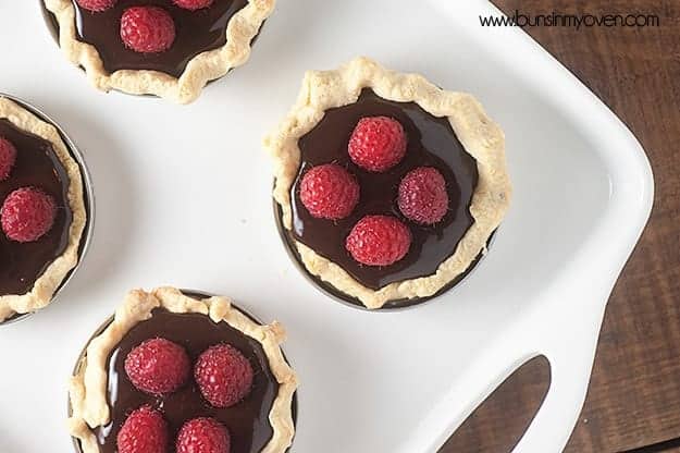 Mini chocolate tarts baked in a mason jar lid and topped with fresh berries!