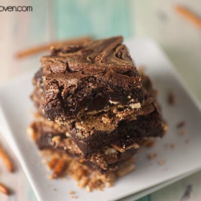 Three square peanut butter brownies on a square plate.