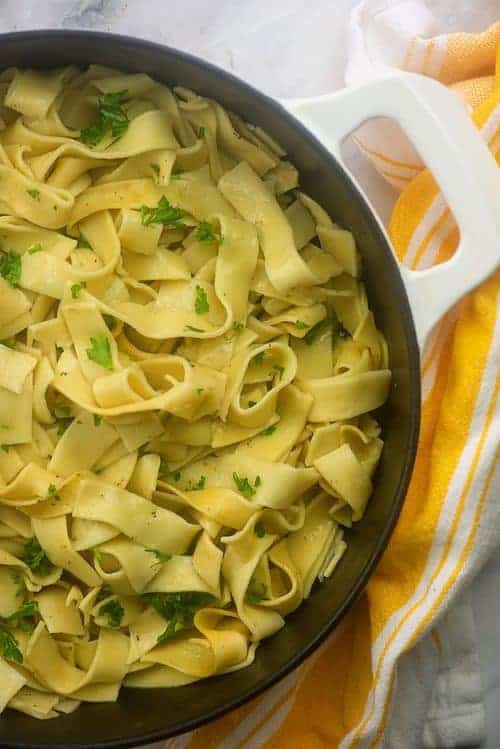 Fideos de huevo en una olla blanca.