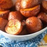A close up of a bowl of roasted potatoes.