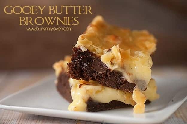 Two stacked up gooey butter brownies on a square plate.