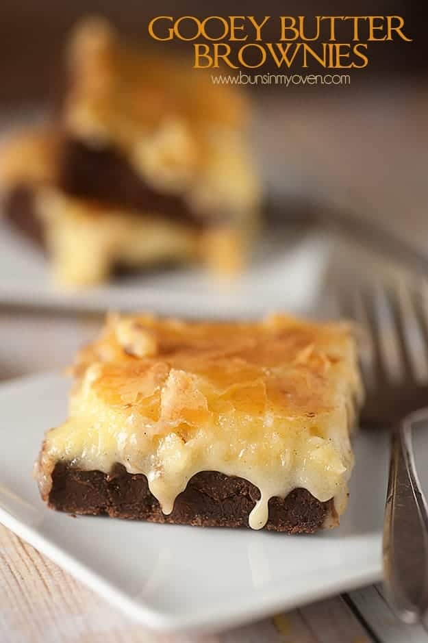 A close up of a gooey butter brownie on a whtie plate with a fork.