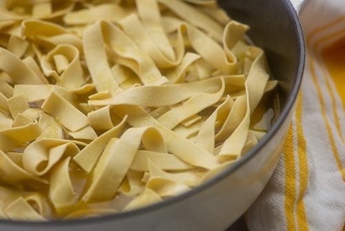 Fideos crudos que entran en la sartén.
