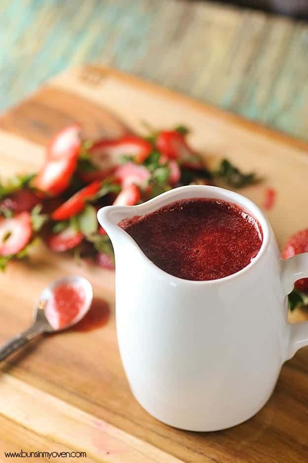 A white pitcher of strawberry syrup.