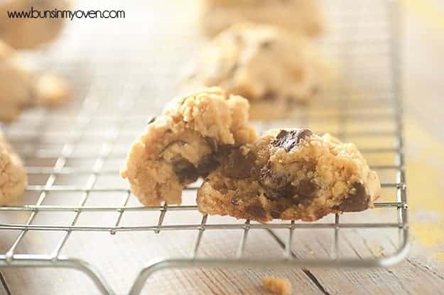 A chocolate chip cookie cooling down on a wire rack.