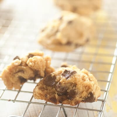 A wire cooling rack stand with a few chocolate chip cookies on it.