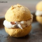 A pumpkin whoopie on a baking sheet with a maple bacon frosting filling.