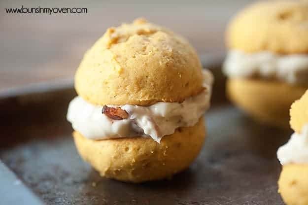A pumpkin whoopie on a baking sheet with a maple bacon frosting filling.