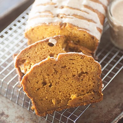 A sliced loaf of pumpkin bread on a wire cooling rack.