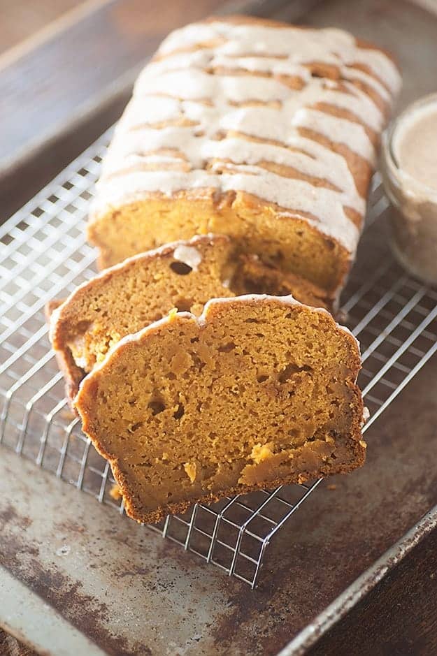 A sliced loaf of pumpkin bread on a wire cooling rack.