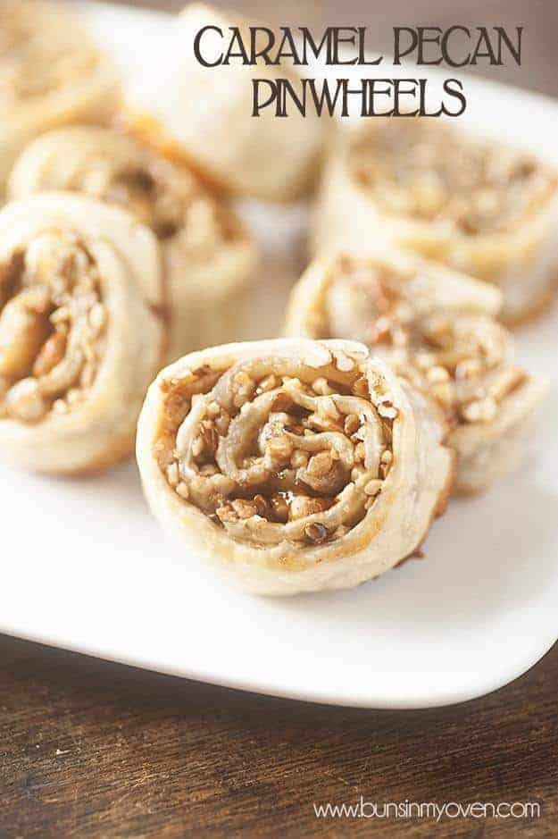 A close up of several caramel pecan pinwheels on a white plate.