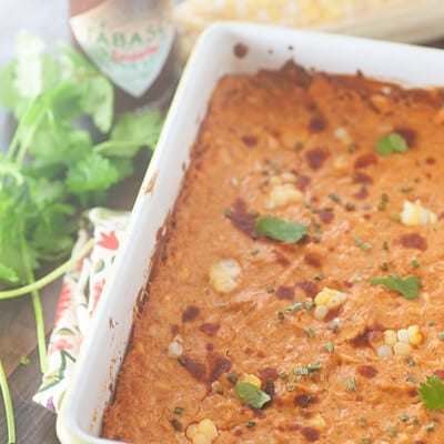 Chicken enchilada dip in a white baking dish on a table.