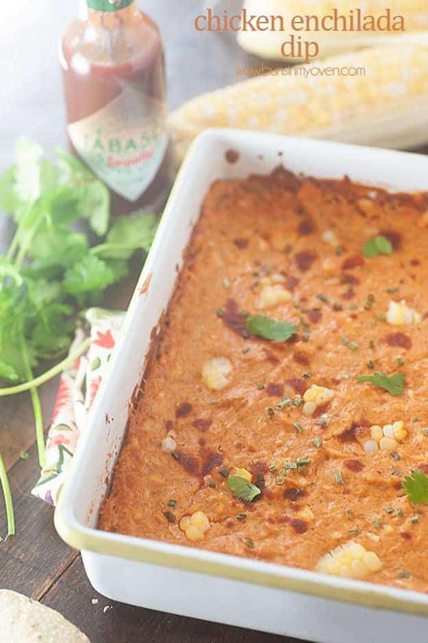 Chicken enchilada dip in a white baking dish on a table.