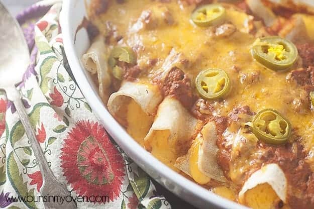 An overhead view of enchiladas in a white baking pan.