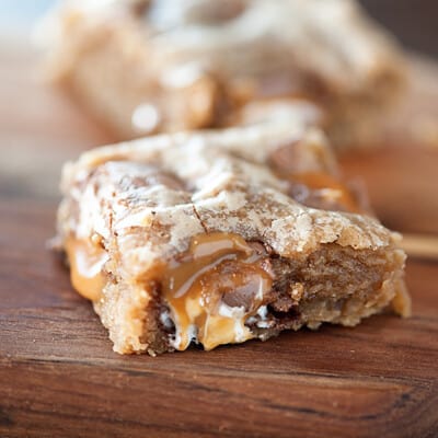 A close up of an apple blondie on a wooden cutting board.