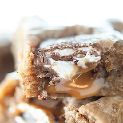A close up of a caramel blondie on top of more blondies.