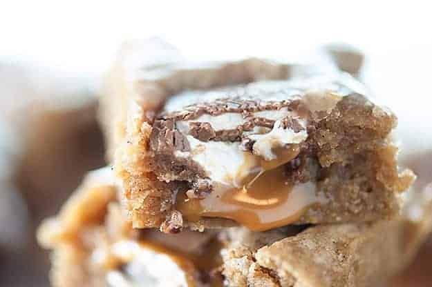 A close up of a caramel blondie on top of more blondies.