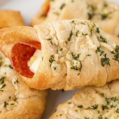 Pepperoni pizza rolls piled on plate.