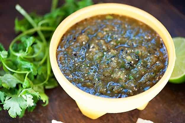 Salsa verde in a bowl on a wooden table.