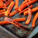 A bunch of sliced carrots on a baking sheet.