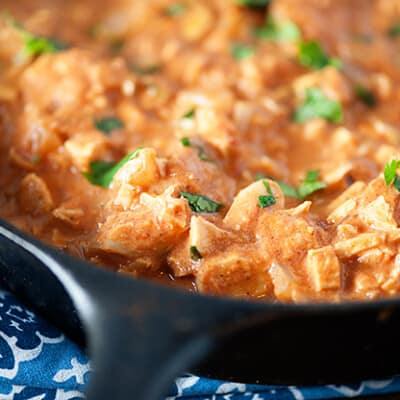 Indian butter chicken in a black cast-iron skillet.