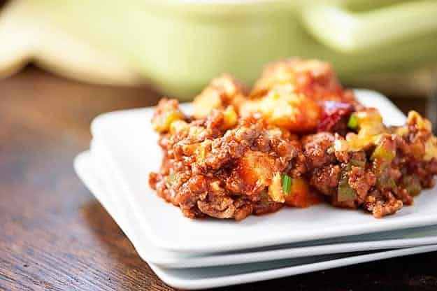 A close up of three square plates topped with sloppy joe casserole.