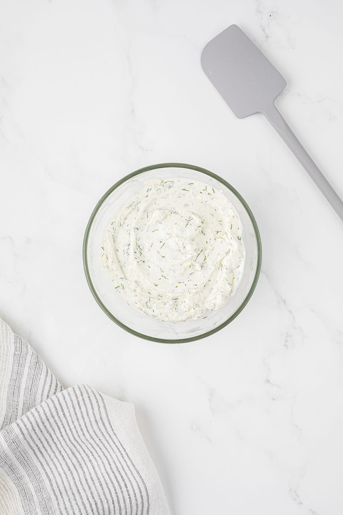 Ricotta and dill in mixing bowl.